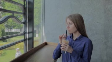 Güzel kız içkiler elma taze oturan tarafından bu pencere.