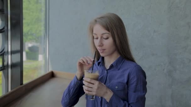 Krásná dívka pije jablko čerstvé sedět u okna. — Stock video