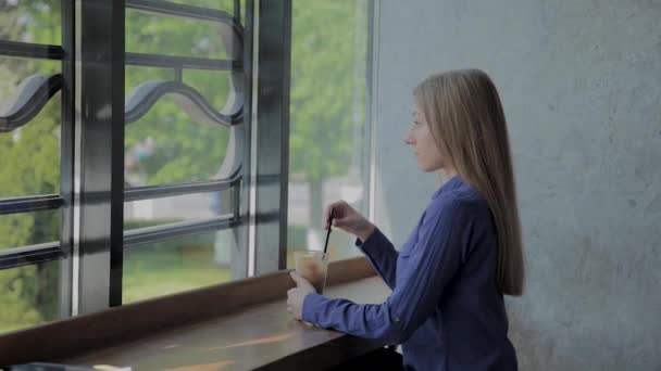 Hermosa chica revolviendo manzana fresca sentada junto a la ventana . — Vídeos de Stock