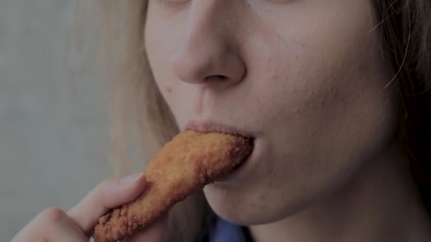 Girl eats nuggets in a fast food restaurant. — Stock Video