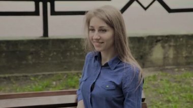 Bir şehir parkında bir bankta oturan güzel kız.