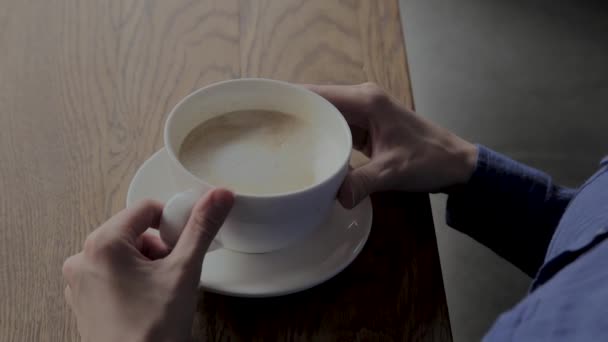 카푸치노 한 잔과 함께 카페에 앉아있는 아름다운 소녀. — 비디오