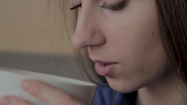 A beautiful girl is sitting in a cafe and drinking coffee. — Stock Video