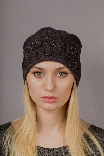 Portrait of a beautiful young girl in a stylish headdress with natural makeup on a gray background. — Stock Photo, Image