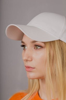 Gri bir arka plan üzerinde doğal makyaj ile şık bir başlık güzel bir genç kız Portresi.