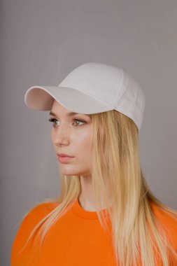 Gri bir arka plan üzerinde doğal makyaj ile şık bir başlık güzel bir genç kız Portresi.