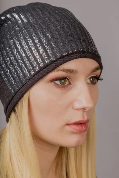 Portrait of a beautiful young girl in a stylish headdress with natural makeup on a gray background. — Stock Photo, Image