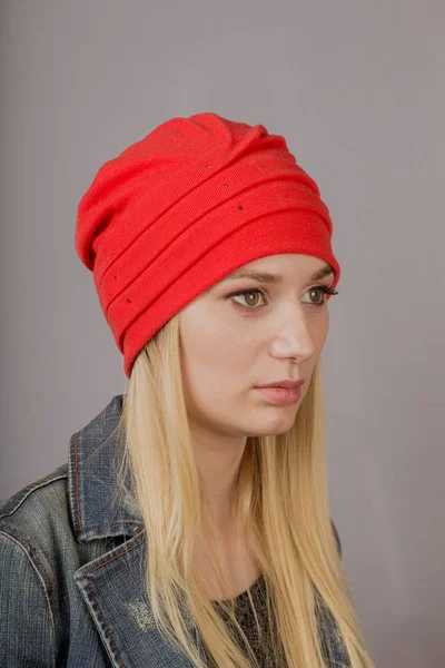 Portrait of a beautiful young girl in a stylish headdress with natural makeup on a gray background. — Stock Photo, Image