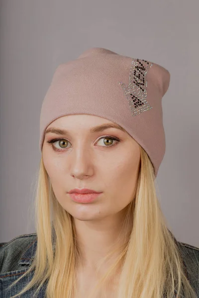 Portrait of a beautiful young girl in a stylish headdress with natural makeup on a gray background. — Stock Photo, Image