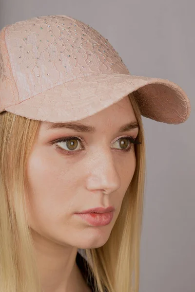 Portrait of a beautiful young girl in a stylish headdress with natural makeup on a gray background. — Stock Photo, Image