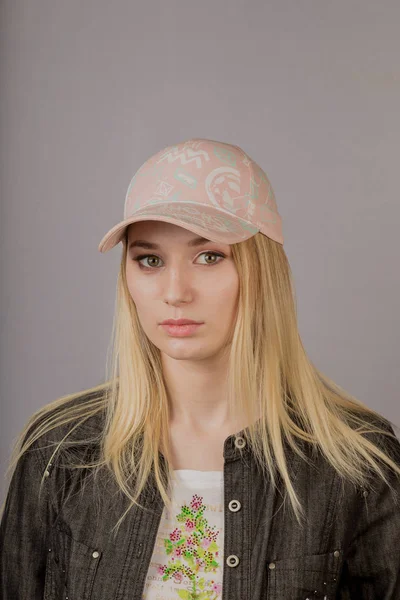 Portrait d'une belle jeune fille dans une coiffure élégante avec un maquillage naturel sur un fond gris . — Photo