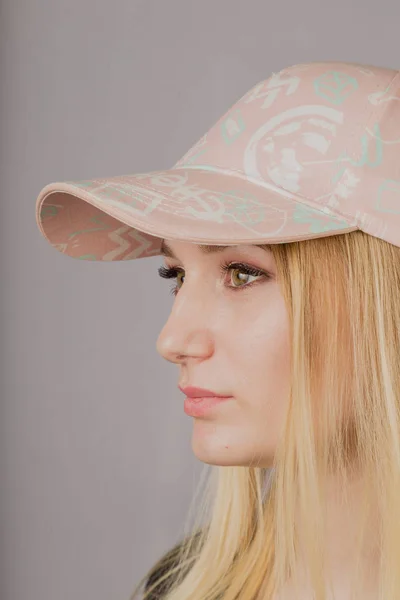 Portrait of a beautiful young girl in a stylish headdress with natural makeup on a gray background. — Stock Photo, Image