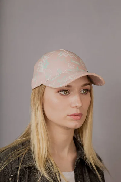 Portrait of a beautiful young girl in a stylish headdress with natural makeup on a gray background. — Stock Photo, Image