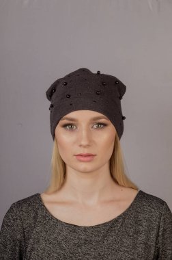 Gri bir arka plan üzerinde bir başlık doğal makyaj ile güzel kız.