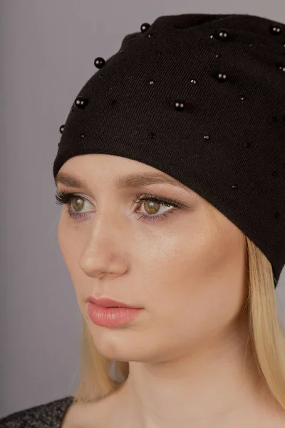 Schöne Mädchen mit natürlichem Make-up in einem Kopfschmuck auf grauem Hintergrund. — Stockfoto