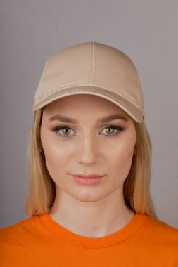 Gri bir arka plan üzerinde bir başlık doğal makyaj ile güzel kız.