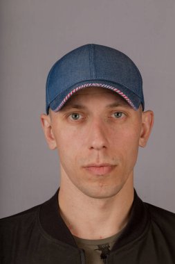 Gri bir arka plan üzerinde bir başlık yakışıklı genç adam.