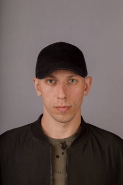 Gri bir arka plan üzerinde bir başlık yakışıklı genç adam.