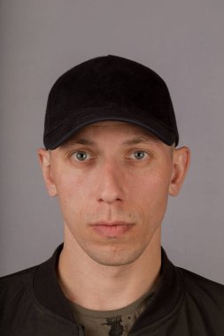 Gri bir arka plan üzerinde bir başlık yakışıklı genç adam.