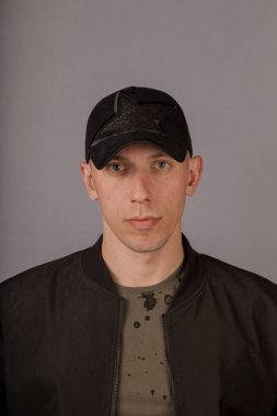 Gri bir arka plan üzerinde bir başlık yakışıklı genç adam.