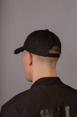 Gri bir arka plan üzerinde bir başlık yakışıklı genç adam.