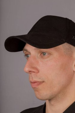 Gri bir arka plan üzerinde bir başlık yakışıklı genç adam.