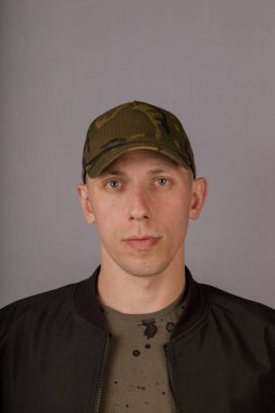 Gri bir arka plan üzerinde bir başlık yakışıklı genç adam.