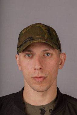 Gri bir arka plan üzerinde bir başlık yakışıklı genç adam.