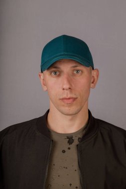 Gri bir arka plan üzerinde bir başlık yakışıklı genç adam.