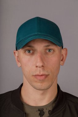 Gri bir arka plan üzerinde bir başlık yakışıklı genç adam.