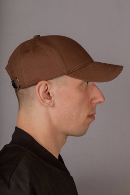 Gri bir arka plan üzerinde bir başlık yakışıklı genç adam.