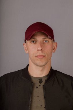 Gri bir arka plan üzerinde bir başlık yakışıklı genç adam.