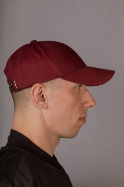 Gri bir arka plan üzerinde bir başlık yakışıklı genç adam.