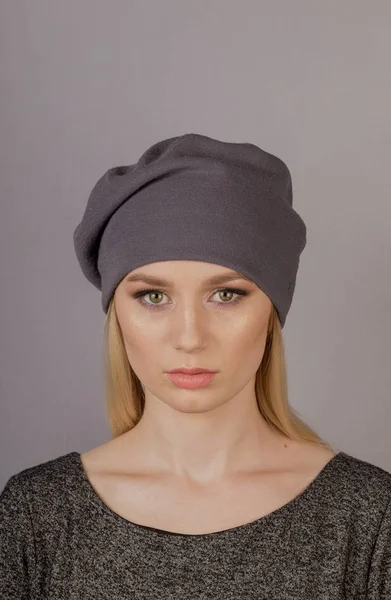 Beautiful girl with natural make-up in a headdress on a gray background. — Stock Photo, Image