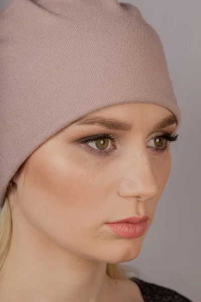 Красивая девушка с натуральным макияжем в головном уборе на сером фоне . — стоковое фото