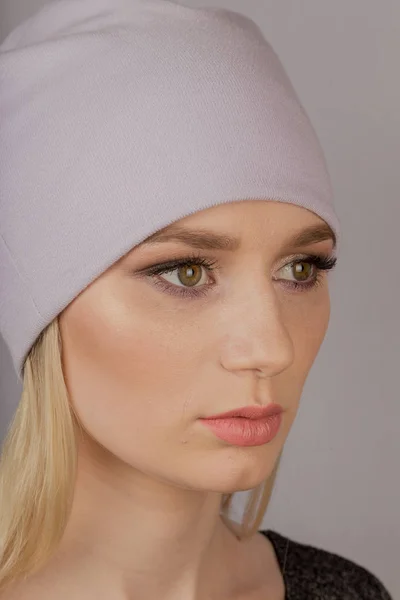 Beautiful girl with natural make-up in a headdress on a gray background. — Stock Photo, Image