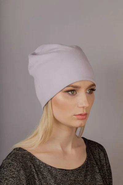 Beautiful girl with natural make-up in a headdress on a gray background. — Stock Photo, Image