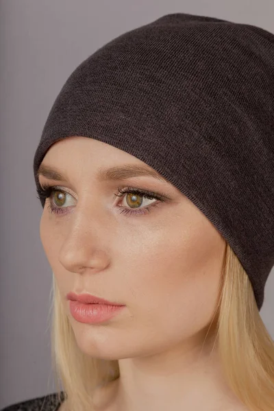 Hermosa chica con maquillaje natural en un tocado sobre un fondo gris . —  Fotos de Stock