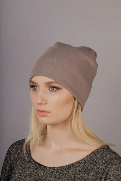 Vacker flicka med naturlig make-up i en huvudbonad på en grå bakgrund. — Stockfoto