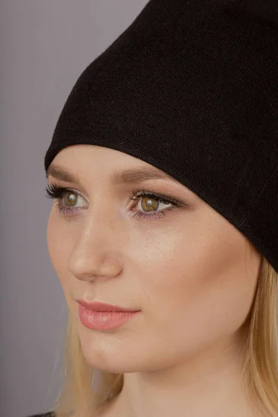 Hermosa chica con maquillaje natural en un tocado sobre un fondo gris . —  Fotos de Stock