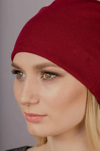 Mooi meisje met natuurlijke make-up in een hoofdtooi op een grijze achtergrond. — Stockfoto