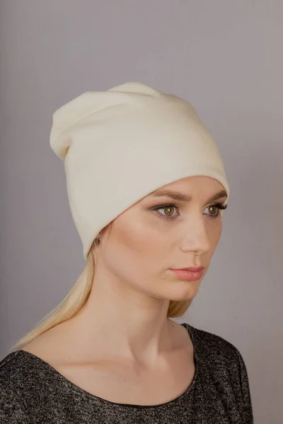 Beautiful girl with natural make-up in a headdress on a gray background. — Stock Photo, Image