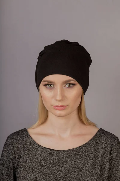 Beautiful girl with natural make-up in a headdress on a gray background. — Stock Photo, Image