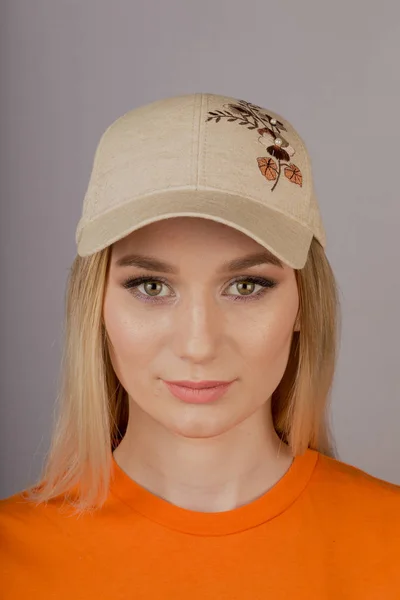 Mooi meisje met natuurlijke make-up in een hoofdtooi op een grijze achtergrond. — Stockfoto