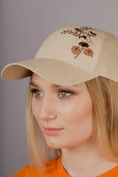 Mooi meisje met natuurlijke make-up in een hoofdtooi op een grijze achtergrond. — Stockfoto