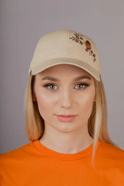 Vacker flicka med naturlig make-up i en huvudbonad på en grå bakgrund. — Stockfoto