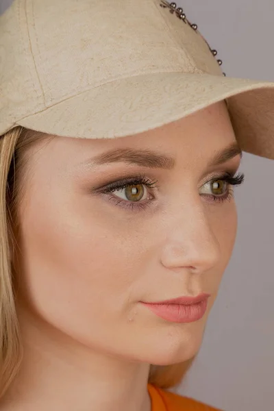 Mooi meisje met natuurlijke make-up in een hoofdtooi op een grijze achtergrond. — Stockfoto