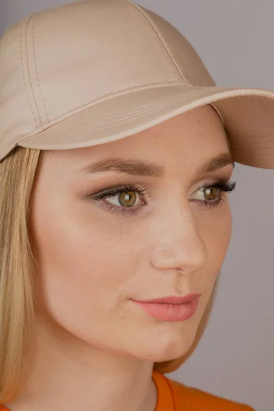 Mooi meisje met natuurlijke make-up in een hoofdtooi op een grijze achtergrond. — Stockfoto