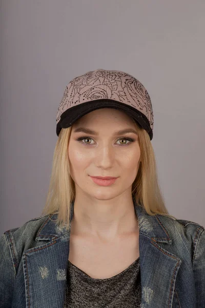 Mooi meisje met natuurlijke make-up in een hoofdtooi op een grijze achtergrond. — Stockfoto