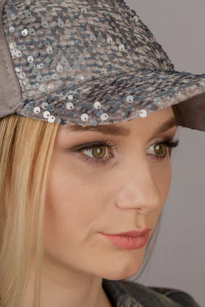 Beautiful girl with natural make-up in a headdress on a gray background. — Stock Photo, Image